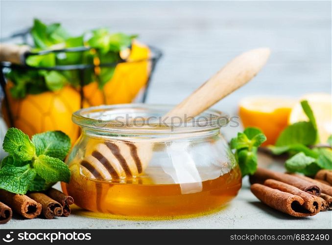 honey in glass bank and on a table