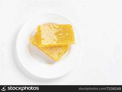 honey in honeycombs on a white plate. view from above