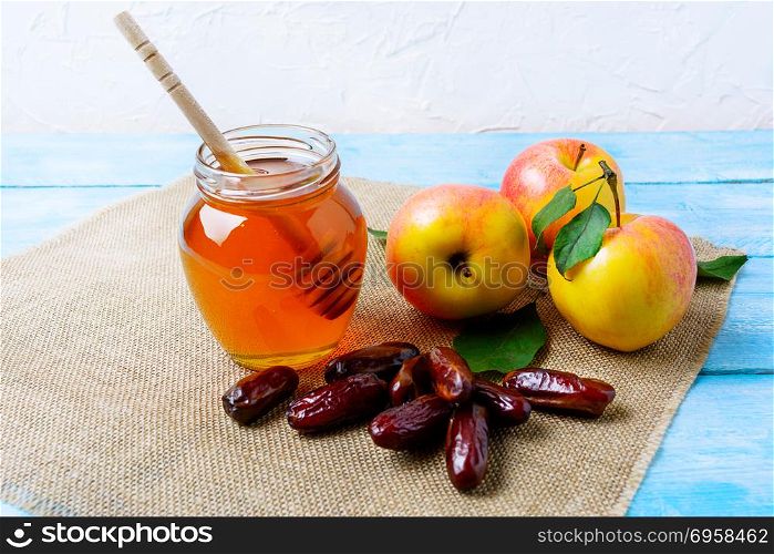 Honey jar, dates and apples on burlap napkin. Rosh hashanah concept. Jewesh new year symbols. . Honey jar, dates and apples on burlap napkin