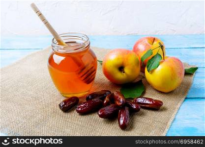 Honey jar, dates and apples on burlap napkin. Rosh hashanah concept. Jewesh new year symbols. . Honey jar, dates and apples on burlap napkin