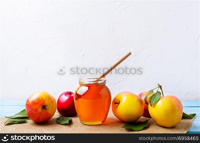 Honey jar with dipper and apples on white background. Honey jar with dipper and apples on white background. Rosh hashanah concept. Jewesh new year symbols. Copy space.