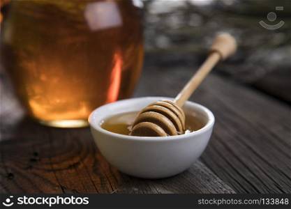 Honey jar with dipper and flowing honey. Jar of liquid honey