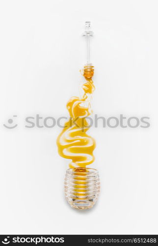 Honey poured from glass jar with spoon on white background, top view. Healthy food