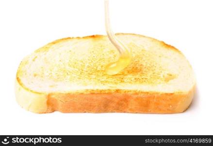 honey pouring down to white bread. isolated on white