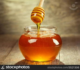 Honey pouring into bowl on wooden