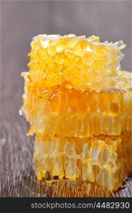 Honey with honeycombs on wooden background