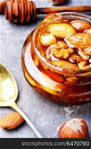 Honey with nuts. Honey with walnuts, almonds and hazelnuts. Natural food