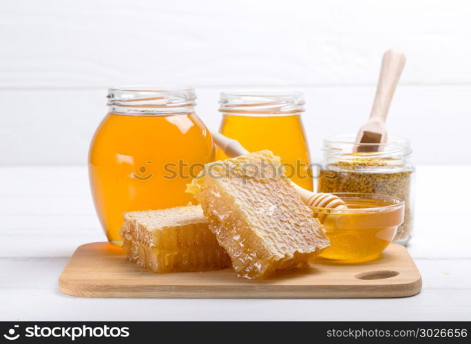 Honey with wooden honey dipper on wooden table