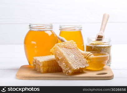 Honey with wooden honey dipper on wooden table