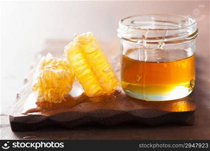 honeycomb and honey in jar on wooden background