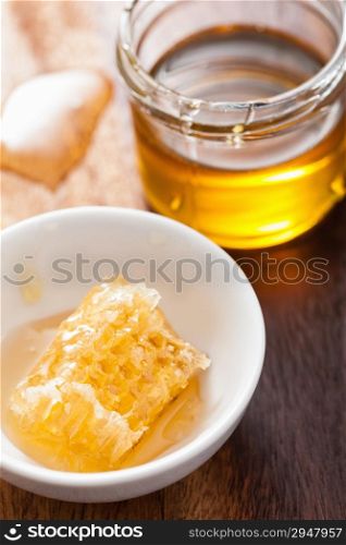 honeycomb and honey jar on wooden background