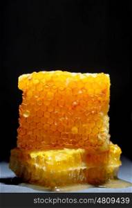 Honeycomb and honey on black ardesia plate