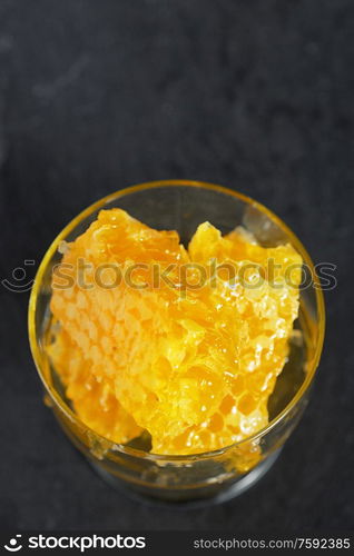 Honeycomb and honey on black ardesia plate