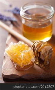 honeycomb dipper and glass jar on wooden background