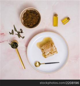 honeycomb honey ceramic plate with cosmetics products against pink textured backdrop