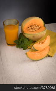 Honeydew melon juice on a wooden table background.