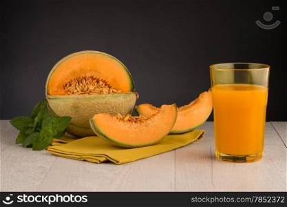 Honeydew melon juice on a wooden table background.