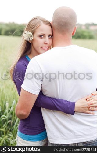 Honeymoom couple hugging each other, woman looking at us outdoor