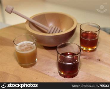 Honeys Assortment Type inside Glass and Wooden Honey Dipper and Bowl