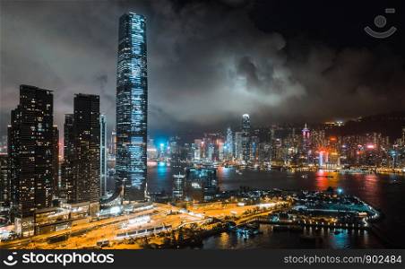 Hong Kong cityscape at night, skyscrapers and tall buildings at Victoria Harbour, drone aerial view. Asia travel destination, Asian tourism, modern city life, or business finance and economy concept
