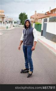 Hooded afroamerican guy with skates on the street with a wall background