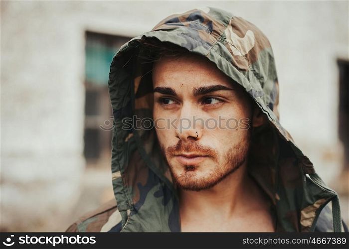 Hooded guy with camouflage jacket in the street