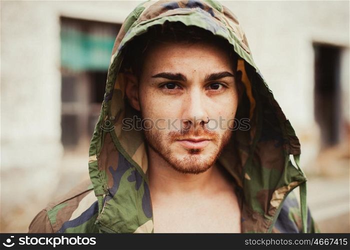 Hooded guy with camouflage jacket in the street