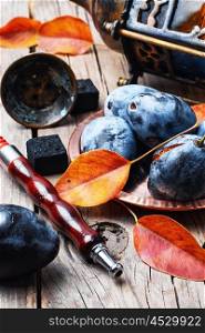 Hookah and autumn plum. Still life with smoking hookah and the harvest of autumn plums