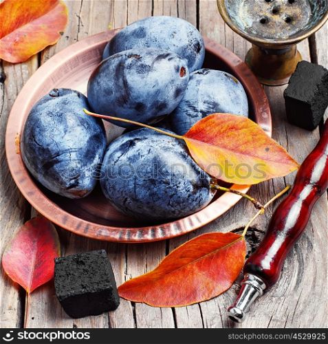 Hookah and autumn plum. Still life with smoking hookah and the harvest of autumn plums