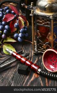 Hookah ,bunch of grapes and stylish Arabic lantern with candle