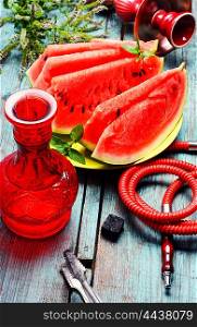 Hookah flavor watermelon. Still life with slices of ripe watermelon and smoking hookah