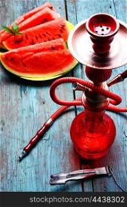 Hookah flavor watermelon. Still life with slices of ripe watermelon and smoking hookah