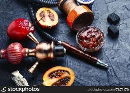 Hookah or shisha with tobacco with tamarillo aroma.Arabian shisha. Oriental smoking hookah with tamarillo