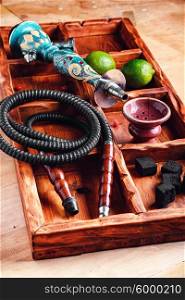 Hookah set and accessories. Wooden box with hookah smoking accessories and fruits of lime