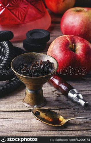 Hookah with apple flavor. Arab hookah metal and scattered tobacco leaf