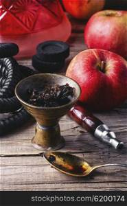Hookah with apple flavor. Arab hookah metal and scattered tobacco leaf