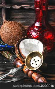 Hookah with coconut flavor. Stylish Oriental hookah and ripe tropical coconut