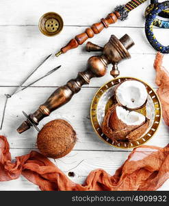 Hookah with coconut taste. Stylish oriental shisha and ripe tropical coconut