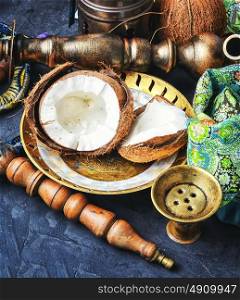 Hookah with coconut taste. Stylish oriental shisha and ripe tropical coconut