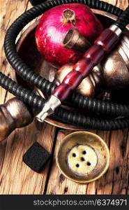 hookah with pomegranate. Exotic smoking shisha in east style with tobacco aroma of pomegranate.Fruit hookah