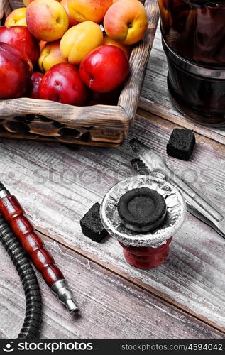 Hookah with the aroma of plums. Smoking Arab hookah and wooden basket with plums