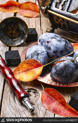 Hookah with the aroma of plums. Smoking hookah accessories and tobacco with taste of autumn plums