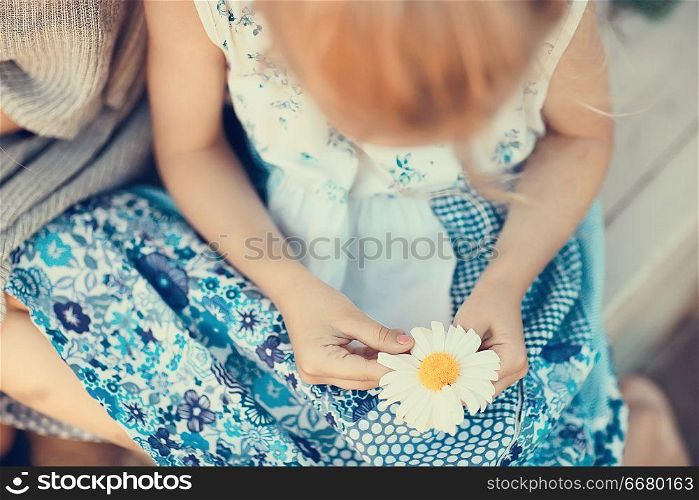 hope, girl guessing on chamomile / baby with chamomile flower, concept divination hope love love friendship