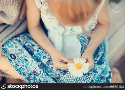 hope, girl guessing on chamomile / baby with chamomile flower, concept divination hope love love friendship