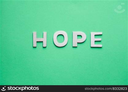                                     hope word with wooden letters on the green background