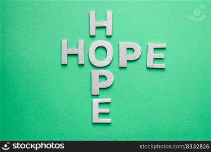 hope word with wooden letters on the green background