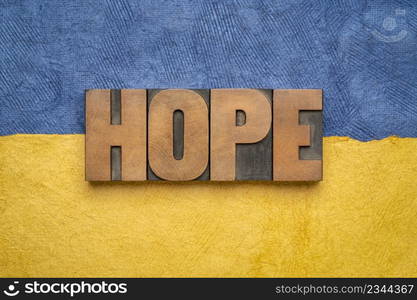 hope word - word abstract in vintage letterpress wood type against paper abstract in blue and yellow colors of Ukraine, faith and optimism concept in difficult time