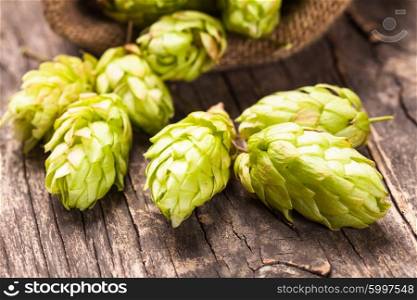 Hops with green leaf on a wooden background with copy space. The hops heap