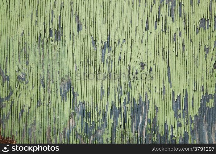 horizontal board with peeling green and blue paint