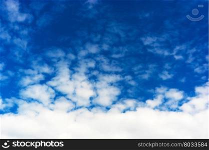 Horizontal bottom aligned white cloudscape on blue sky background. Horizontal bottom aligned white cloudscape on blue sky backgroun